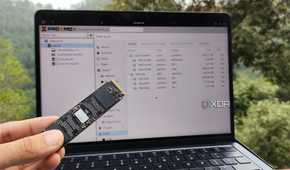 A person holding an SSD in front of Proxmox's web UI
