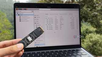 A person holding an SSD in front of Proxmox's web UI