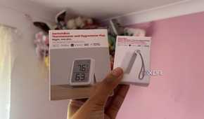 Smart home switchbot sensors held up with pink background