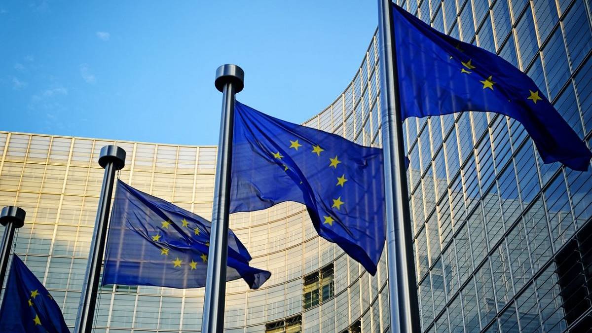 European Union flags with building in the background.