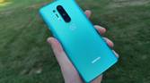 OnePlus 8 Pro in hand with grass in the background.