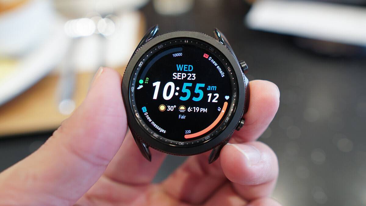 Samsung Galaxy Watch 3 held in a hand with the time and other complications.