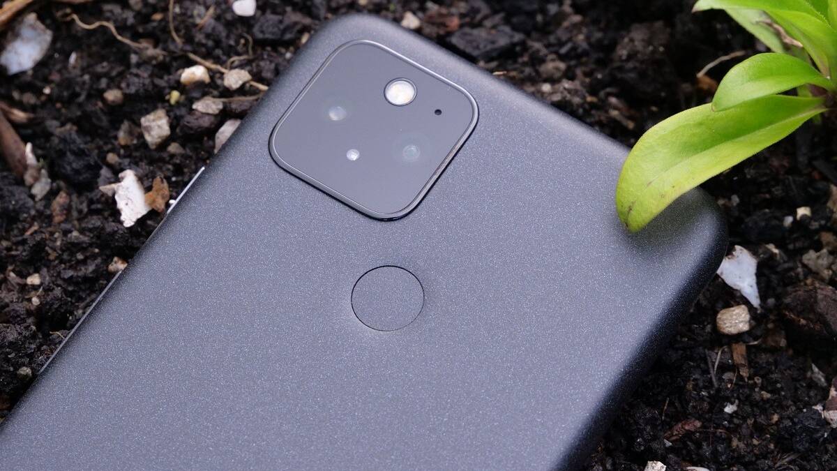 Google Pixel 5 lying in soil bed showing the fingerprint sensor and the camera module
