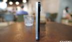Apple iPhone 12 White and the Apple iPhone 12 Pro Pacific Blue standing upright on a table side by side