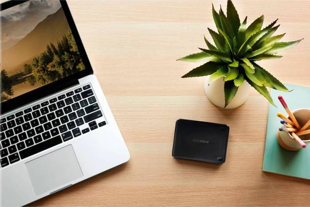wd easystore 4tb hard drive on a desk with plant and computer
