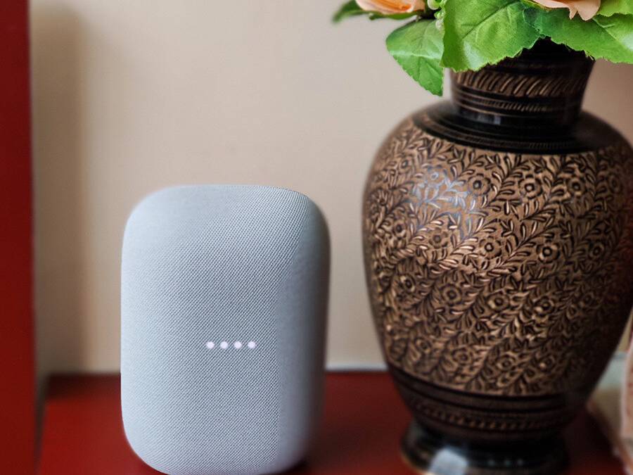 Google-Nest-Audio-XDA-Chalk-on-red-table-besides-flower-vase-apple-airpods