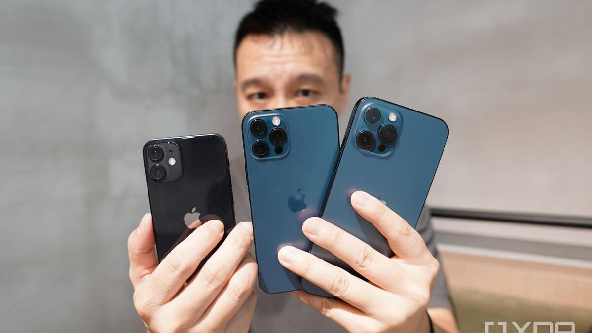 Holding the iPhone 12 Pro Max, iPhone 12 Pro and iPhone 12 Mini.