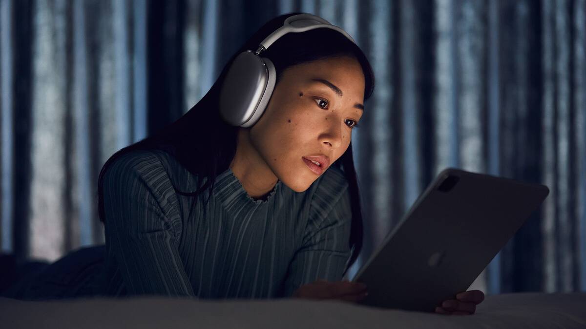 Woman wearing Apple AirPods Max reading off a screen