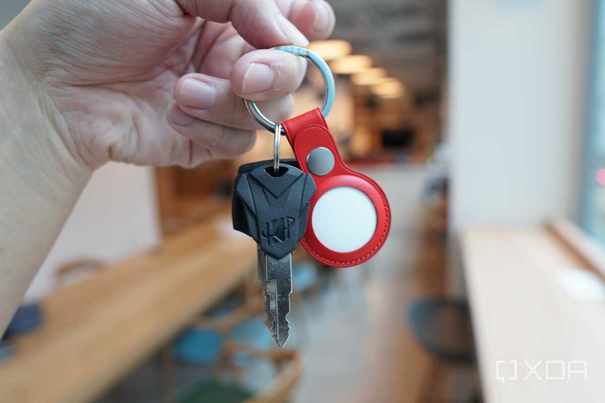 Apple's AirTags in a red leather key ring along with some keys.