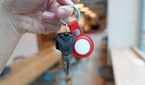 Apple's AirTags in a red leather key ring along with some keys.