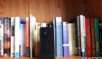 ASUS ZenFone 8 in front of books on a bookshelf