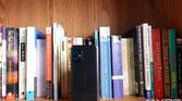 ASUS ZenFone 8 in front of books on a bookshelf