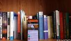 ASUS ZenFone 8 facing forwards in front of books on a bookshelf