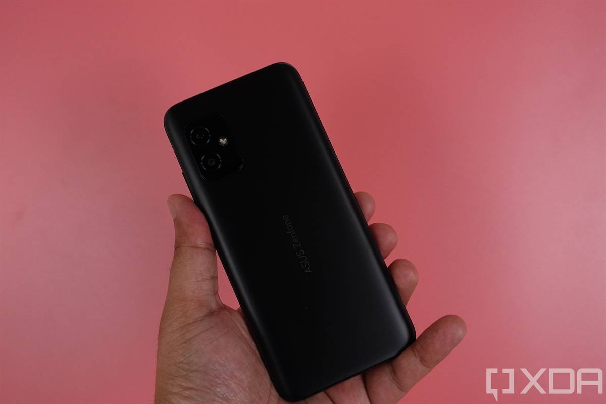 Holding up the ASUS ZenFone 8 against a pink backdrop