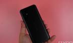 Holding up the ASUS ZenFone 8 against a pink backdrop
