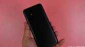 Holding up the ASUS ZenFone 8 against a pink backdrop
