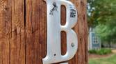 Photo of a letter 'B' on a wooden post
