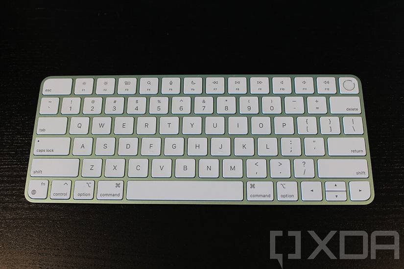 Green Magic Keyboard with Touch ID on black desk