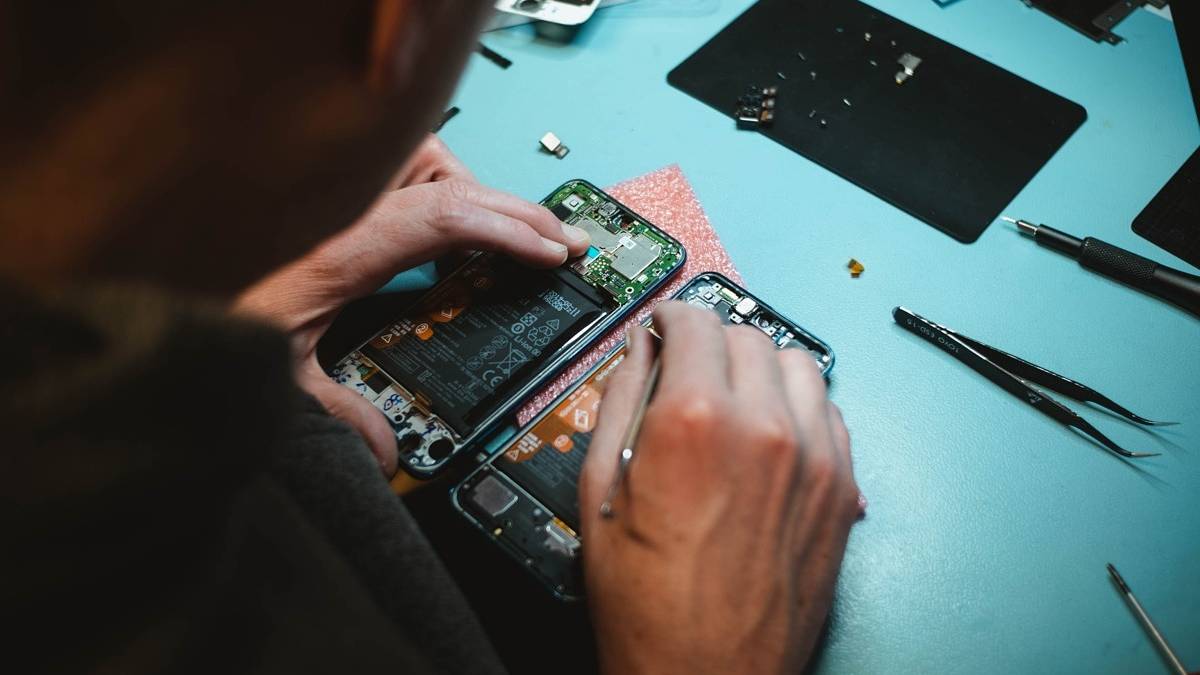 A person trying to repair a smartphone