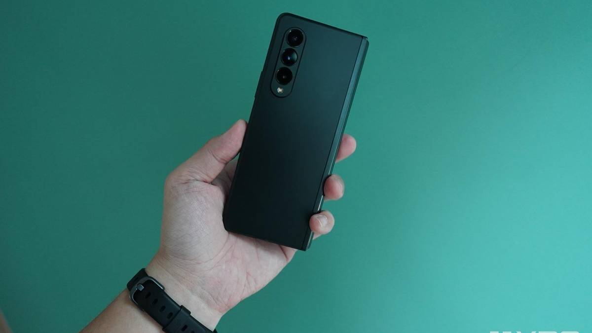 Galaxy Z Fold 3 in hand with green background