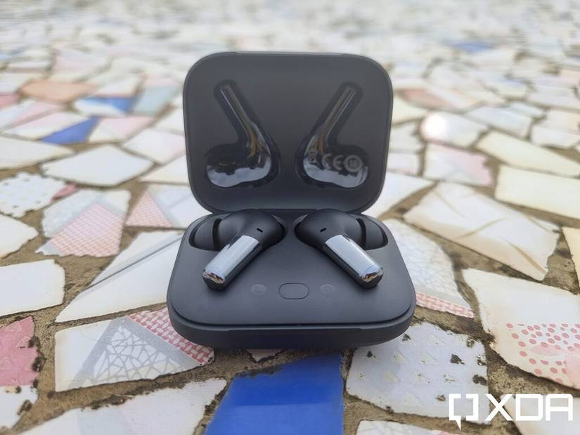 OnePlus Buds Pro earbuds kept on a chipped tile floor