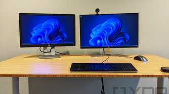 Wooden desk with keyboard and two monitors on top