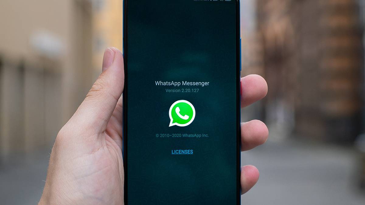 WhatsApp messenger splash screen on phone in hand