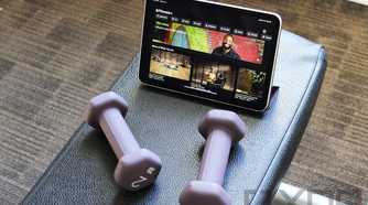 Purple dumbbells and iPad mini with Apple Fitness+