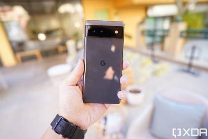 Google Pixel 6 in hand with blurred background.