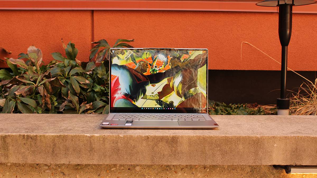 Open laptop on cement bench with red background