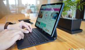 Two hands typing on a Magic Keyboard attached to an iPad Air 5 (2022) sitting on a table