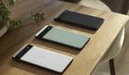 Google Pixel 6a in all three colors on wooden table.