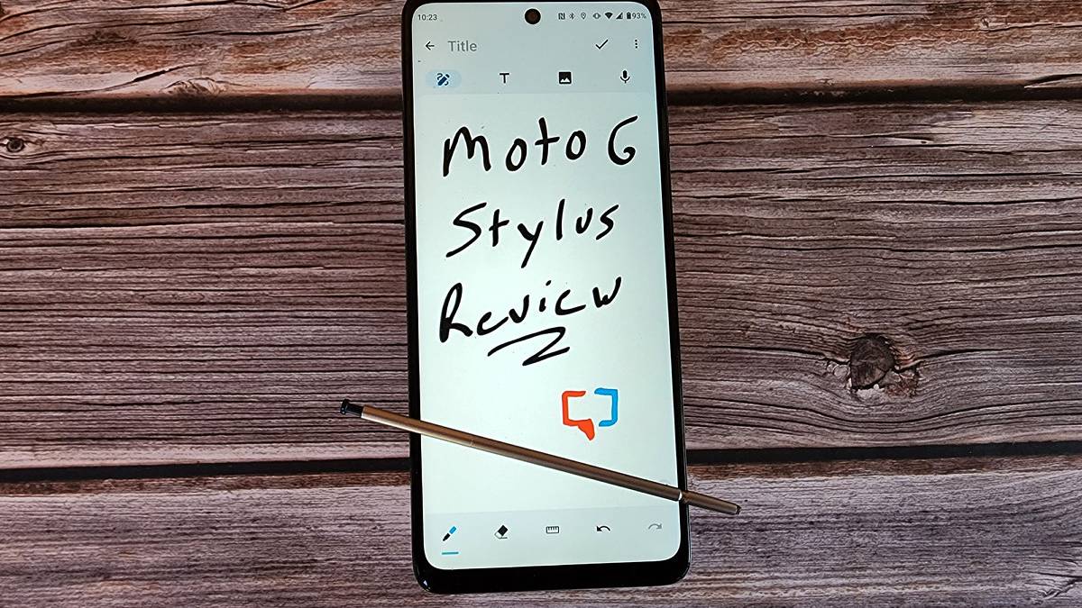 The Moto G stylus rests on a table with words written on the screen.