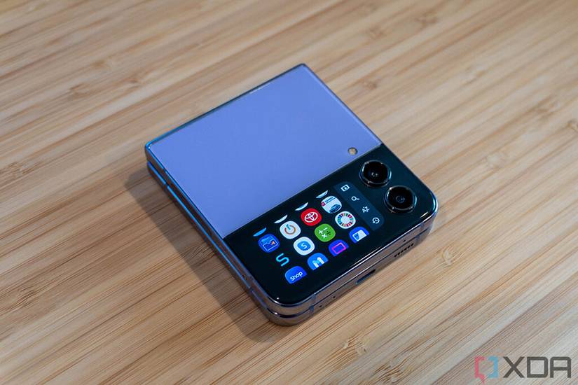 CoverScreen OS running on a blue Galaxy Z Flip 4 on wooden background.