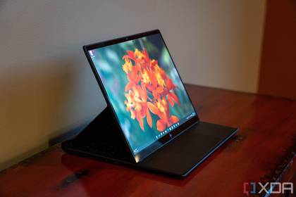 Angled view of the HP Elite Dragonfly Folio on a wooden table, with the screen pulled forward to cover the keyboard.
