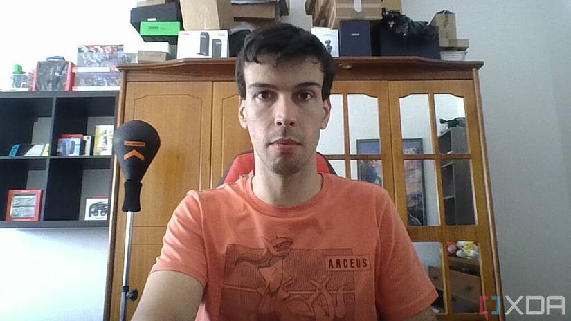 A picture of a man sitting on a chair with furniture in the background. The picture was taken by the webcam on the Lenovo ThinkBook 13s Gen 4 laptop.
