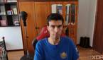 A picture of a man sitting on a chair with a wardrobe in the background. The picture was taken with the Obsbot Tiny 4K webcam