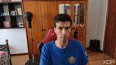A picture of a man sitting on a chair with a wardrobe in the background. The picture was taken with the Obsbot Tiny 4K webcam