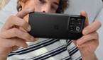 A person hold a OnePlus 10T smartphone in Moonstone black color