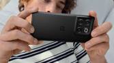 A person hold a OnePlus 10T smartphone in Moonstone black color