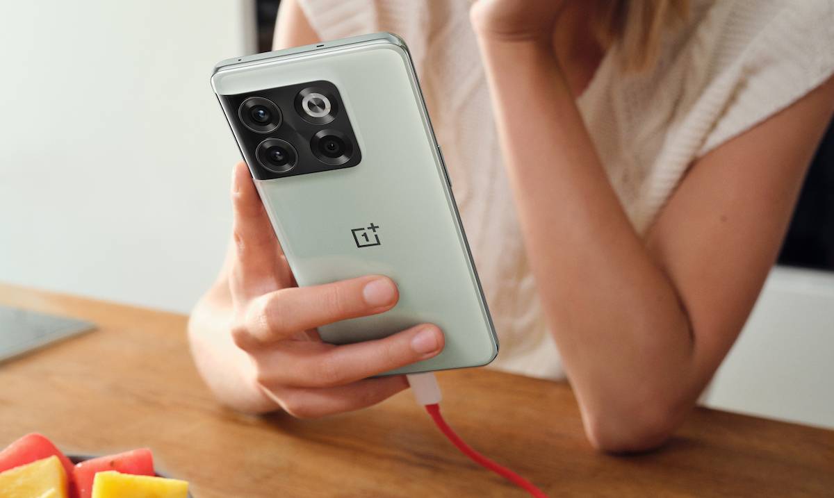 A person holding the OnePlus 10T smartphone in Jade Green color