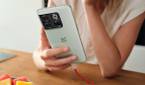 A person holding the OnePlus 10T smartphone in Jade Green color