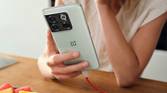 A person holding the OnePlus 10T smartphone in Jade Green color