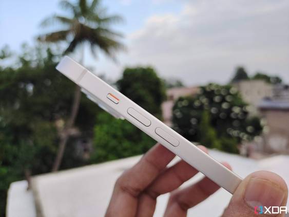 iPhone 14 held. in hand with the mute switch and volume buttons vislble