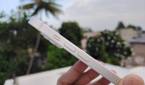 iPhone 14 held. in hand with the mute switch and volume buttons vislble