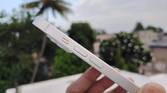 iPhone 14 held. in hand with the mute switch and volume buttons vislble