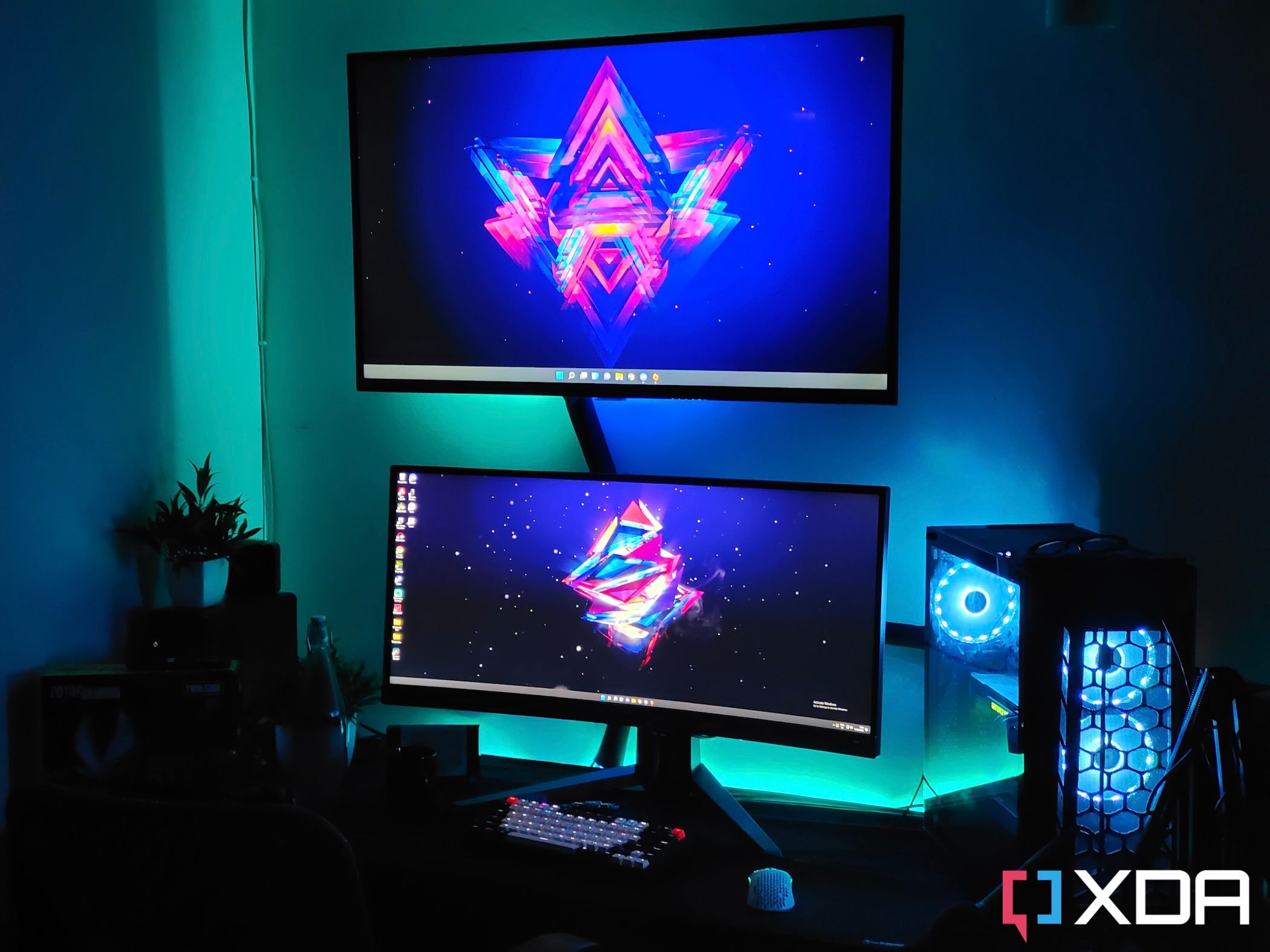 Una imagen que muestra una configuración de juego con un televisor, un monitor y una carcasa de PC para juegos en un escritorio con algunas luces RGB.