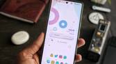 An image showing a person holding the Google Pixel 7 in hand with a bunch of miscellaneous items in the background.