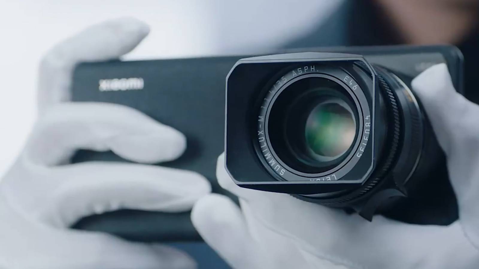 Person wearing gloves holding the Xiaomi 12S Ultra concept with a Leica M-series lens.