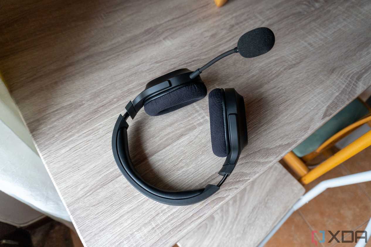 A Razer Barracuda X headset resting on a table with the detachable microphone plugged in